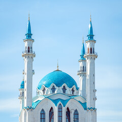 Beautiful white mosque with a blue roof against the blue sky.