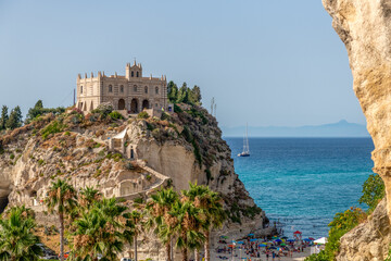 Fototapeta premium klasztor na wzgórzu na tle pięknego morza i samotnej żaglówki