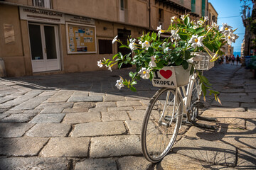 Urocza uliczka w Tropea, rower z tabliczką będący miejscem spotkań młodzieży - obrazy, fototapety, plakaty