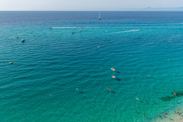 turyści pływający na materacach i uprawiający sporty wodne u wybrzeża Tropea w Kalabrii - obrazy, fototapety, plakaty