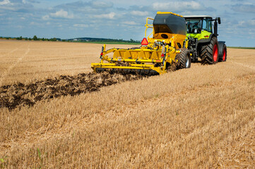 Fototapeta na wymiar fragment of a disk cultivator, system of tillage in work with the bunker for fertilizers in the field