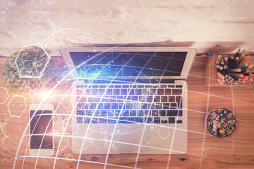 Double exposure of map hologram drawing over study table background with computer. Concept of international network. Top view.