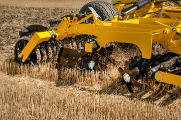 cultivator at work, close up of a disc harrow on a field background - obrazy, fototapety, plakaty