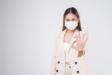 portrait of young businesswoman wearing a surgical mask over white background studio