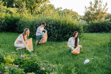 A group of girls with children at sunset are engaged in garbage collection in the park....