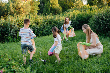A group of girls with children at sunset are engaged in garbage collection in the park....