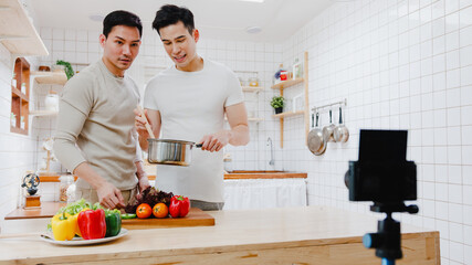 Asia gay couple blogger vlogger and online influencer recording video content on healthy food in...