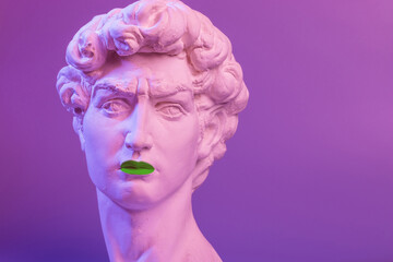 Gypsum copy of the sculpture David Michelangelo with green lips on purple background