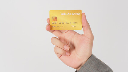 Hand wear grey suit is holding gold credit card on white background.