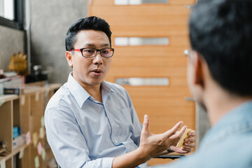 Asia businesspeople chatting to intern discussing job interview colleagues having conversation and communication meeting brainstorming ideas about project working plan success strategy in office. - obrazy, fototapety, plakaty