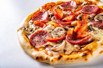Pizza with Mozzarella cheese, salami, tomato sauce, onion, pepper, mushrooms