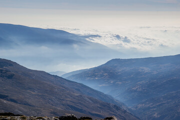 panorama of mountains that intersect with fog and a sea of low clouds in the background in Sierra...