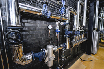 The valves and pipes at a craft modern brewery wall