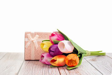 Present box and tulips on wooden rustic table with white background