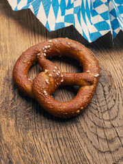 Tasty pretzel with Bavarian flag on a rustic wooden table
