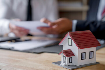 Discussion With A Real Estate Agent, a businesswoman signing a contract for Insurance protecting house, a real estate home is pointing to insurance contract signing and are explaining to customers.