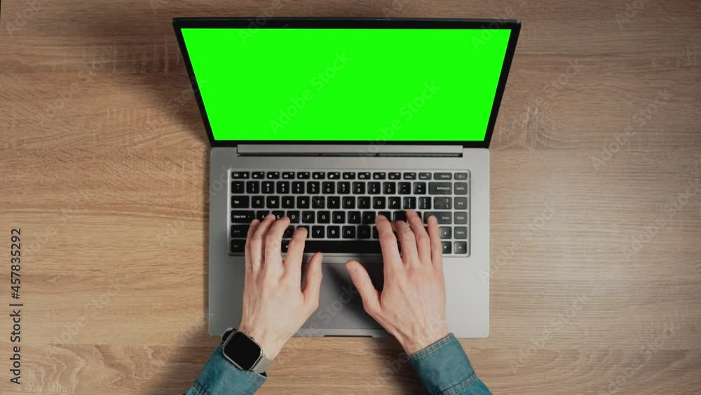 Poster timelapse of man hands are typing on laptop keyboard with green screen. place for pasting content on