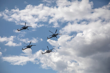 Fototapeta na wymiar Combat helicopters fly against the background of the cloudy sky. Cloudy sky. Beautiful military aircraft.