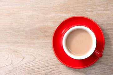 Red cup of coffee on a wooden table