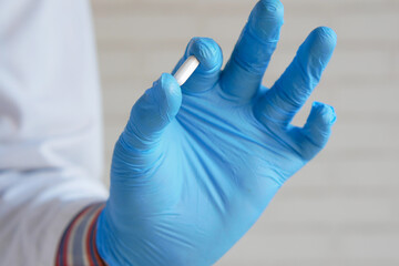 doctor holding in latex gloves holding medical pill 