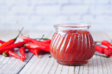 chili and tomato sauce in a small jar on table 