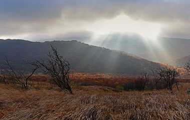 The rays of the sun breaking behind the clouds over Bukowe Berdo, Bieszczady Mountains