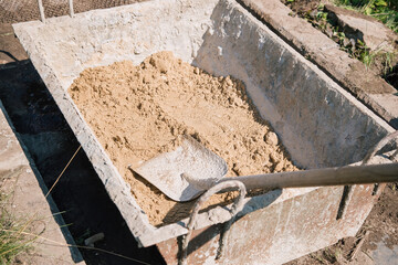 Uploading sand into a cement mixture for pouring a garden path
