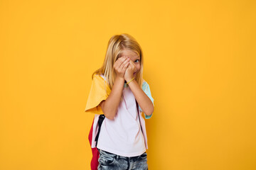 school girl gestures with his hands yellow color background