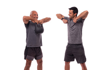 An elderly European man, with a personal trainer, trains, lifting weights, on a white background.
