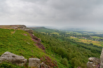Fototapeta na wymiar Along the front of Curbar Edge and Baslow Edge in Derbyshire on a misty, grey summer day