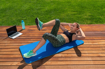 A beautiful European girl, performs exercises for abdominal, remote lessons, a fitness trainer on a...
