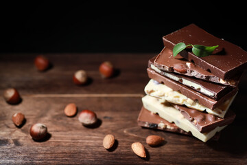 A bar of milk chocolate. Homemade milk chocolate with almonds and dried strawberries. Pieces of milk chocolate. Set of milk chocolate with tea.