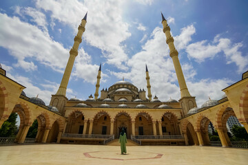Fototapeta na wymiar Female Tourist Enjoying the View of The Akhmad Kadyrov Mosque in Grozny, Chechen Republic, Russia
