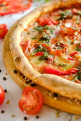 Appetizing, fresh pizza is on the table. Food from an Italian restaurant. Cooking pizza. Pizza ingredients.