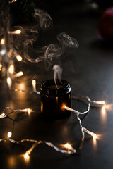 White smoke from an extinguished candle on a contrast dark background. Hygge, christmas decoration...