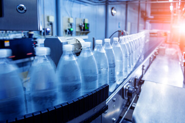 Conveyor belt with bottles of drinking water at a modern beverage plant.