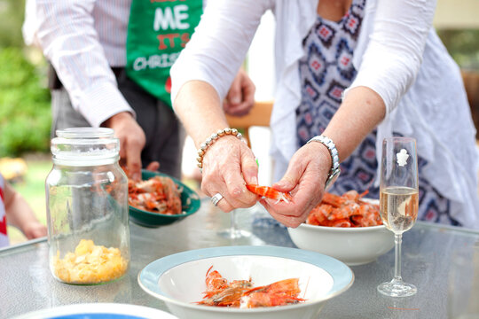 Woman at Christmas time shelling prawns at the table