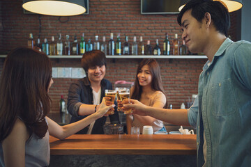 Group of Asian friend clinking a glass of beer and enjoy drinking beer at bar, alcohol, beer drinking, friend party, group of friend, casual meeting, bar and restaurant or friend and beer concept 
