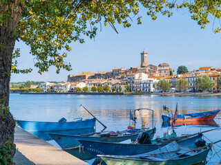 Plakat view through boats to city Marta on lake Bolsena in Italy