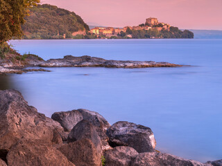 View to Rocca Farnese castle in Capodimonte city in the morning with smooth water in lake Bolsena