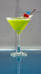 Single cocktail. fresh green cocktail with cherry on city background
