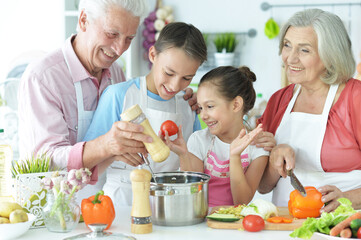 Portrait of family cooking together in kitchen