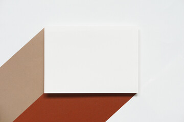 blank clean white mock up brochure with two colors of brown paper and beige paper against white paper background, top view, flat lay.