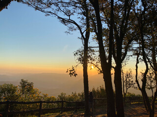 Majestic winter scenery of foggy mountain range at early morning sunrise.