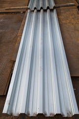Galvanized profiled flooring lying on corrugated metal sheets. Construction production backgrounds.
