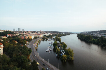 cityscape in Prague on the vltava river with boats, cars and houses