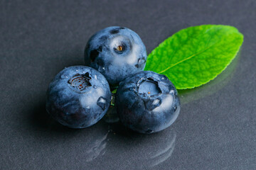 Blueberry with leaves water drops on dark background