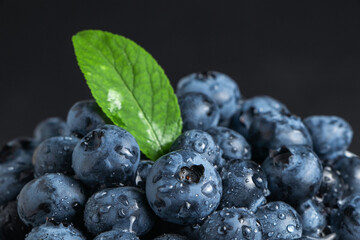 Blueberry with leaves water drops on dark background