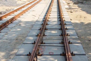 Fototapeta na wymiar Repair of two-way tram tracks, laying of iron rails on reinforced concrete sleepers, the prospect of a repair site to the horizon