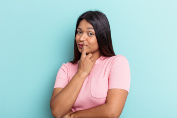 Young Venezuelan woman isolated on blue background unhappy looking in camera with sarcastic...